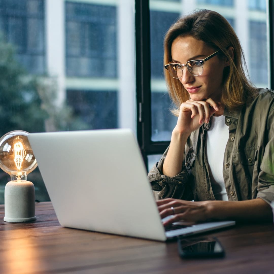 salesperson improving her skills by reading on laptop computer